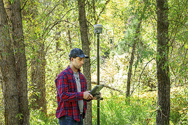 Surveyor using a Trimble R12i GNSS receiver in the field